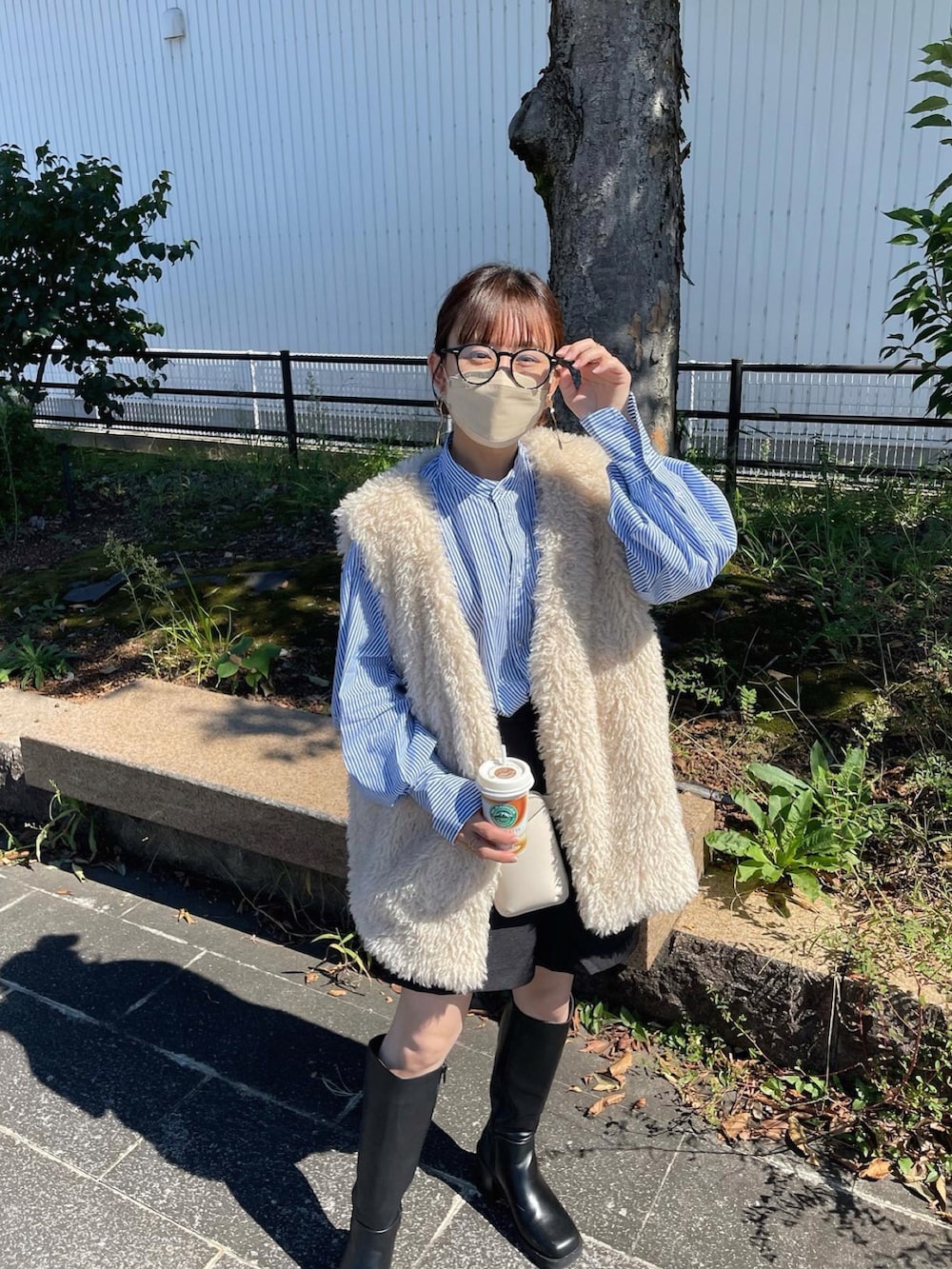 ブルー系のシャツ/ブラウス、ホワイト系のベスト、ブラック系のスラックスを着用したレディースの秋コーディネートの2枚目の写真