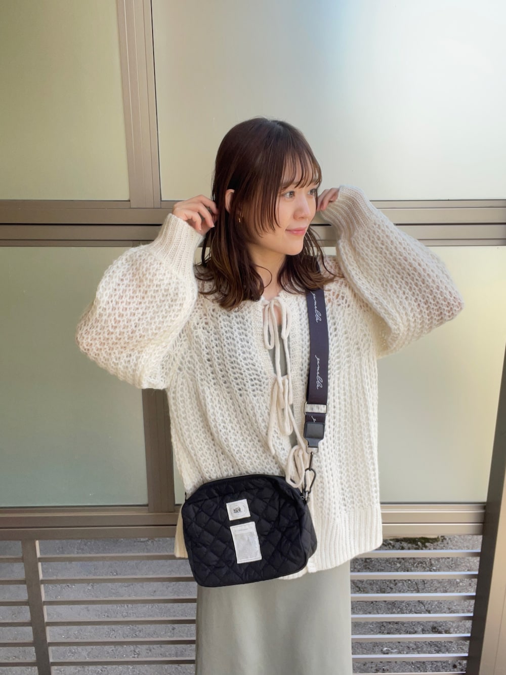 ホワイト系のカーディガン/ボレロ、ブラック系のショルダーバッグ、グリーン系のワンピース/ドレスを着用したレディースの春コーディネートの4枚目の写真