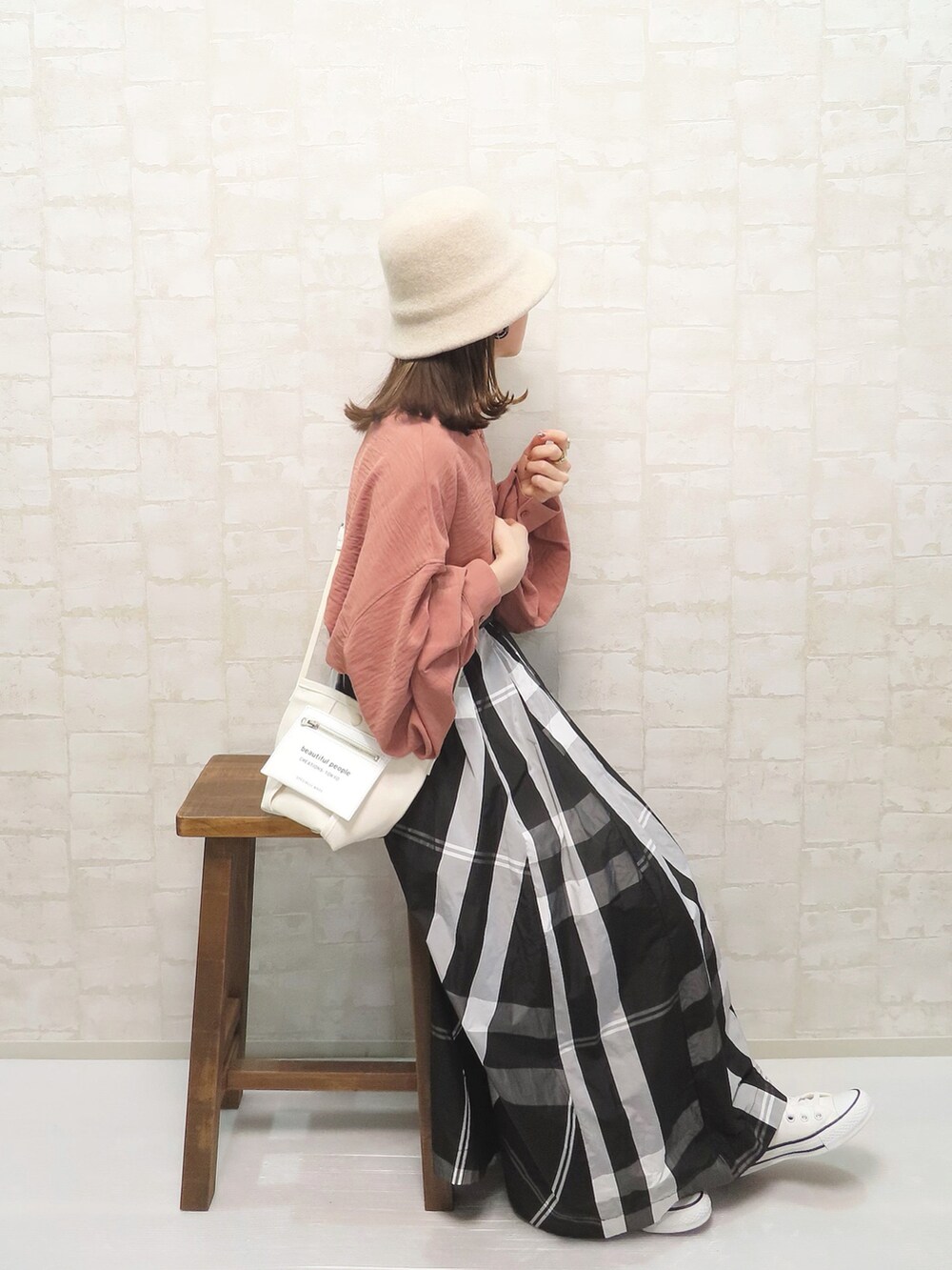 オレンジ系のシャツ/ブラウス、ホワイト系のショルダーバッグ、ホワイト系のスニーカーを着用したレディースの冬コーディネートの2枚目の写真