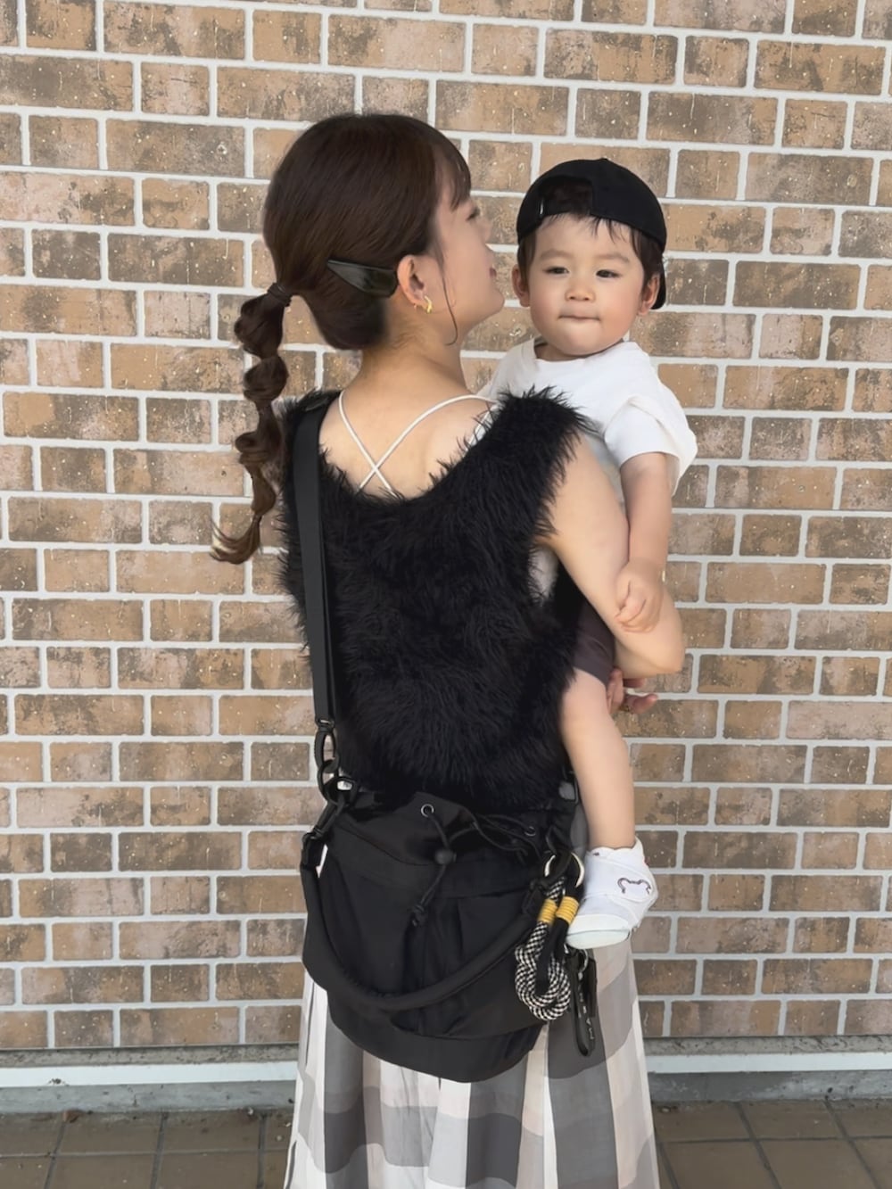 ブラック系のトップス、ベージュ系のスカート、ブラック系のバッグを着用したレディースの秋コーディネートの3枚目の写真