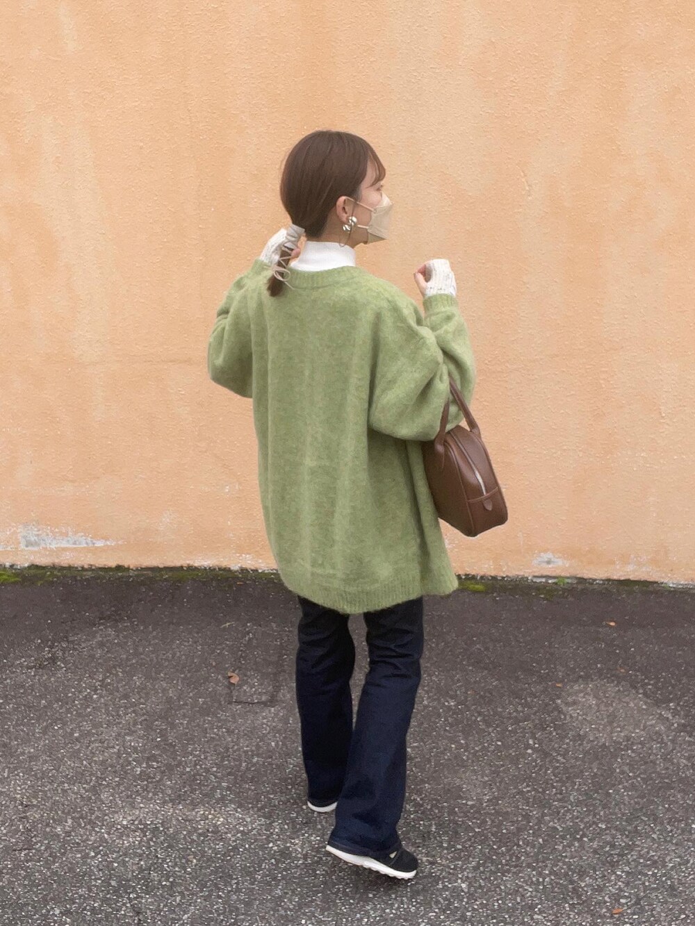 グリーン系のカーディガン/ボレロ、ホワイト系のニット/セーター、ブラウン系のショルダーバッグを着用したレディースの冬コーディネートの5枚目の写真