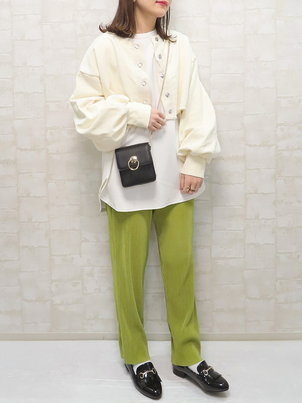 ホワイト系のスウェット、グリーン系のパンツ、ブラック系のショルダーバッグを着用したレディースの春コーディネートの3枚目の写真