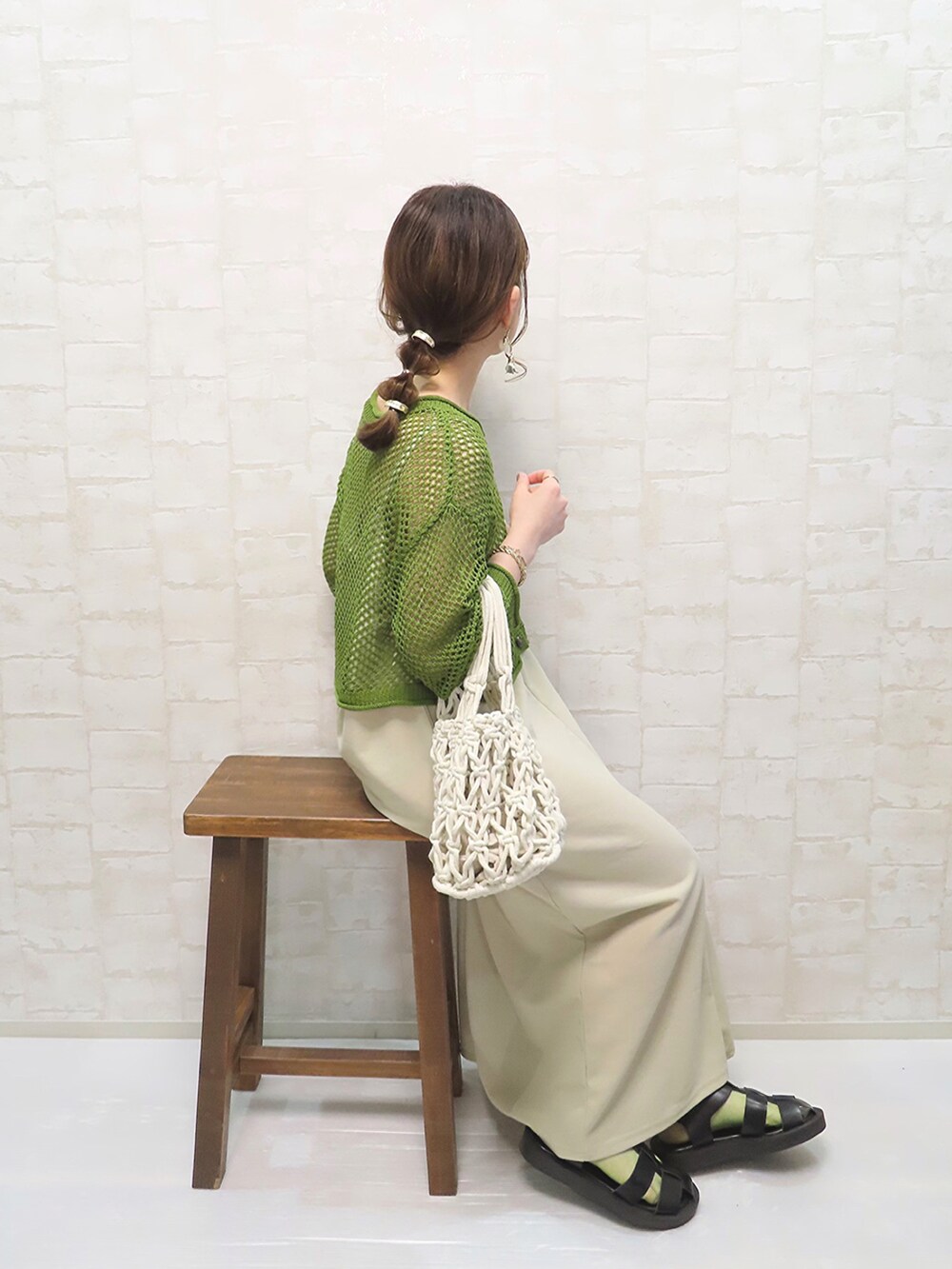 グリーン系のトップス、ホワイト系のハンドバッグ、ベージュ系のワンピース/ドレスを着用したレディースの春コーディネートの2枚目の写真