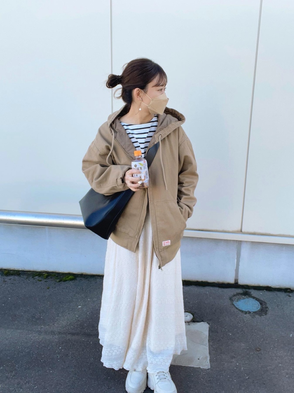 ベージュ系のブルゾン、ホワイト系のTシャツ/カットソー、ベージュ系のスカートを着用したレディースの春コーディネートの2枚目の写真