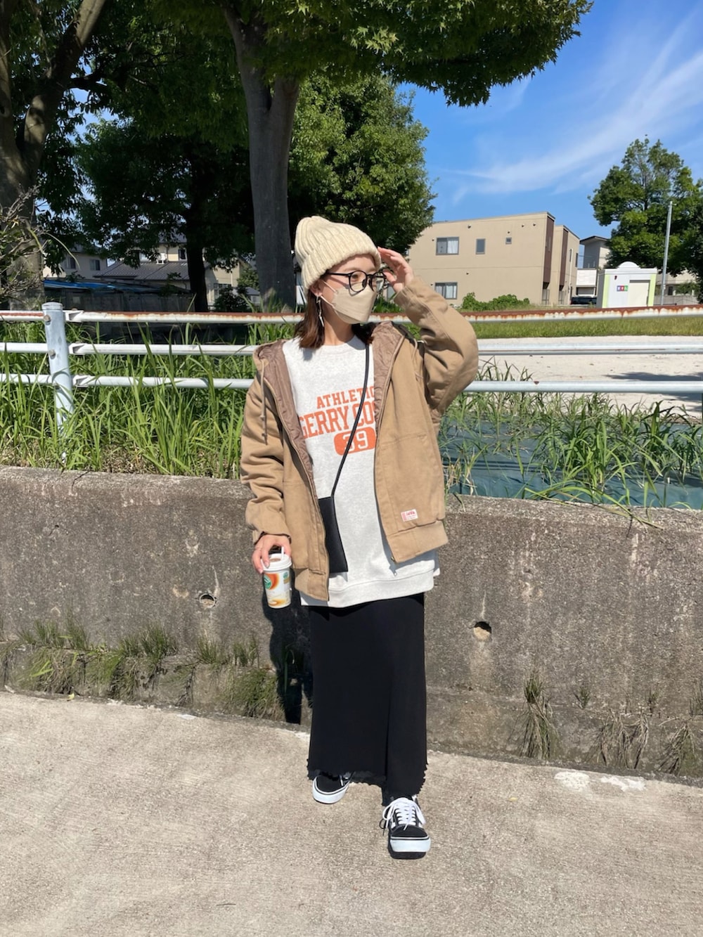 ベージュ系のブルゾン、グレー系のスウェット、ブラック系のワンピースを着用したレディースの秋コーディネートの2枚目の写真