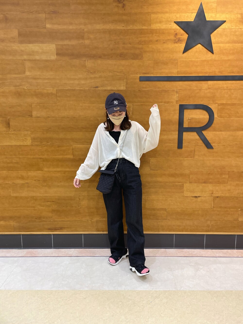 ホワイト系のカーディガン/ボレロ、ブラック系のキャミソール、ブラック系のデニムパンツを着用したレディースの春コーディネートの2枚目の写真