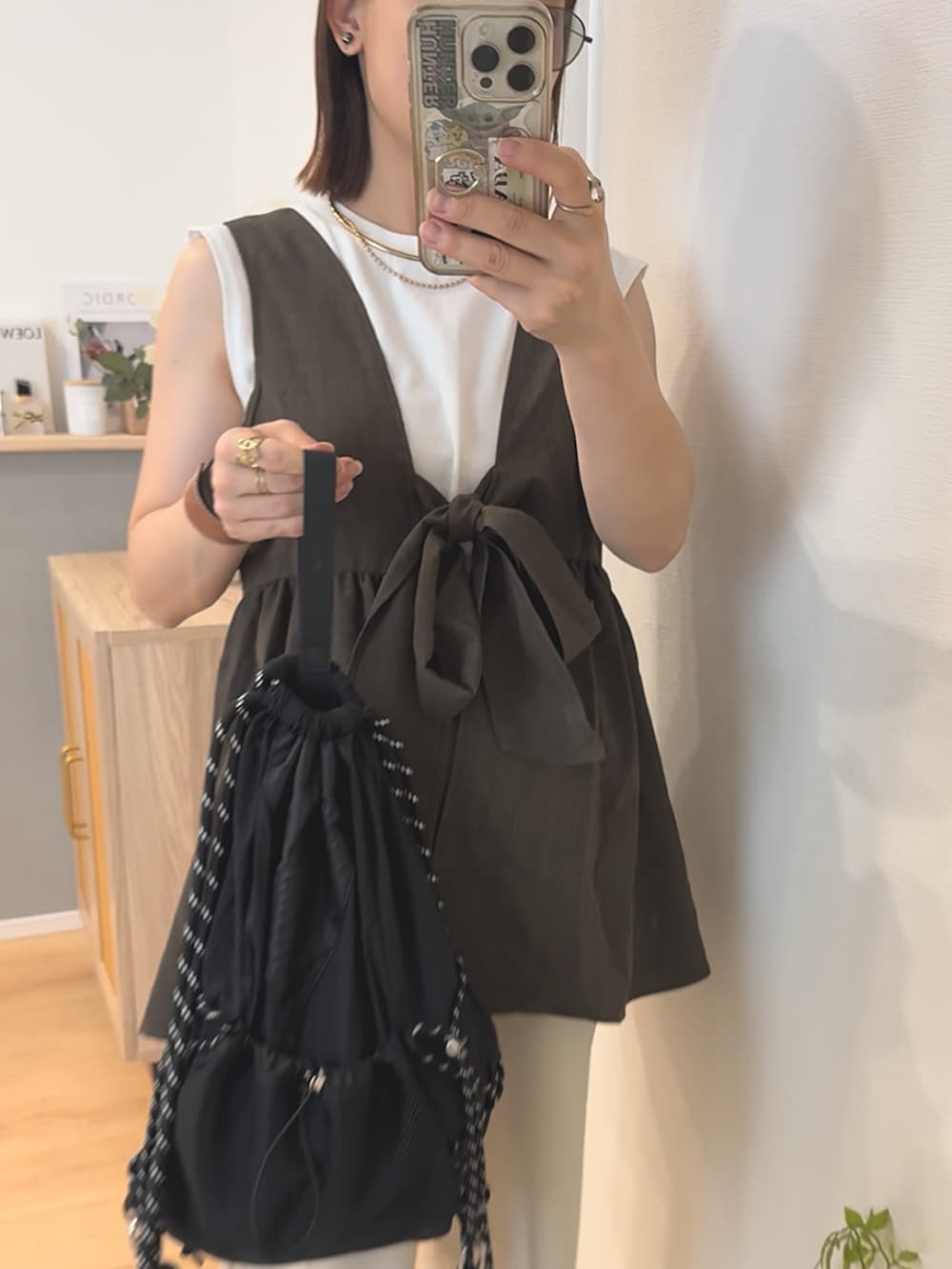 ベージュ系のデニムパンツ、ブラック系のバックパック/リュック、ブラウン系のトップスを着用したレディースの秋コーディネートの2枚目の写真