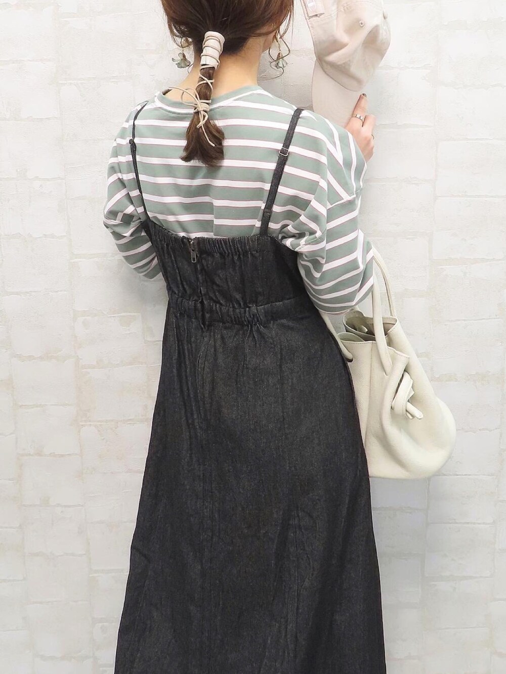 グリーン系のTシャツ/カットソー、ブラック系のワンピース、ホワイト系のハンドバッグを着用したレディースの春コーディネートの2枚目の写真