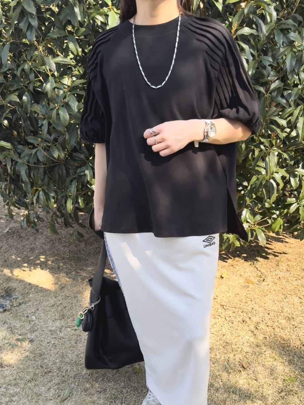 ブラック系のシャツ/ブラウス、ホワイト系のスカート、ベージュ系のスニーカーを着用したレディースの夏コーディネートの4枚目の写真