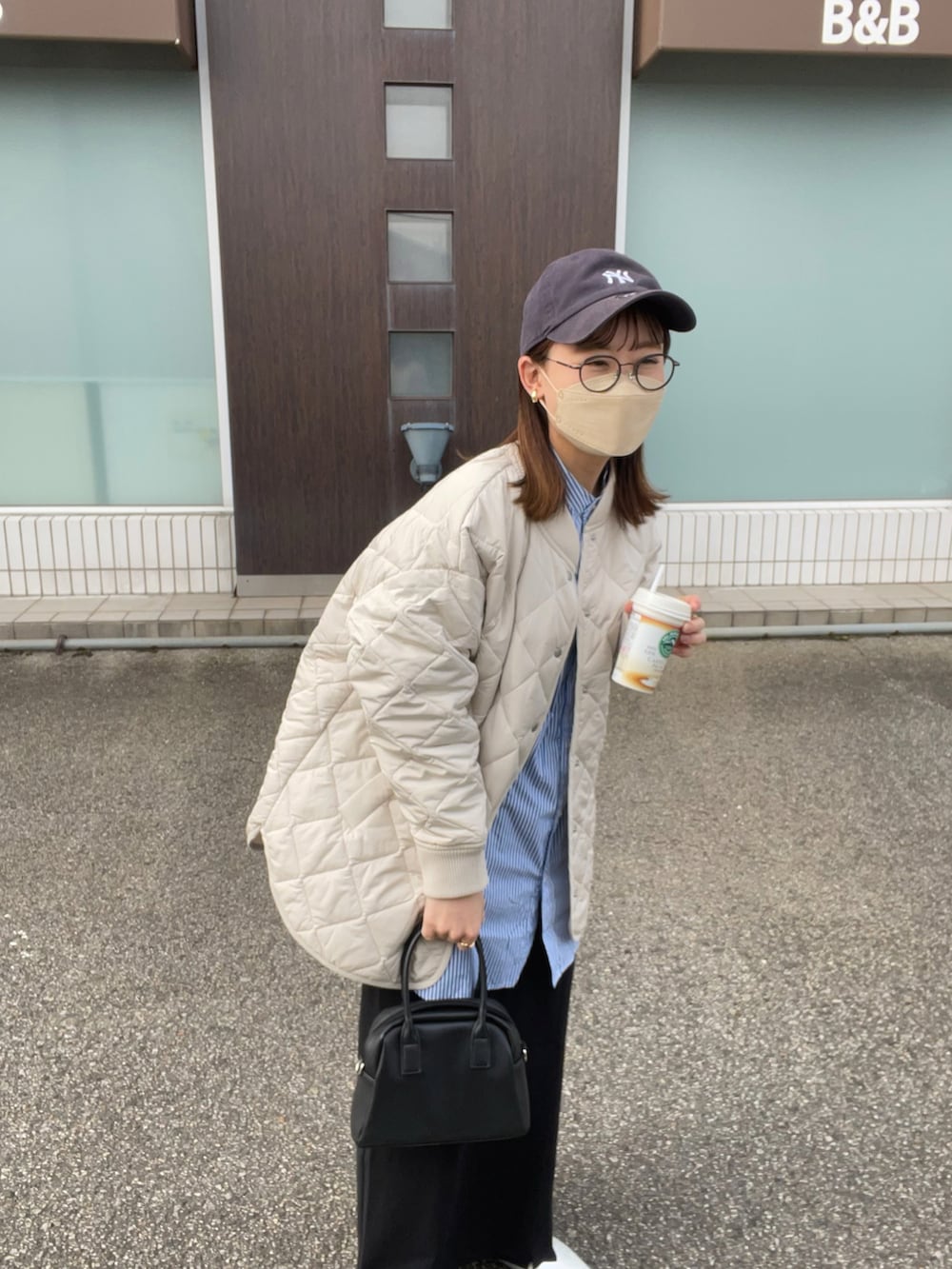 ホワイト系のブルゾン、ブルー系のシャツ/ブラウス、ブラック系のスカートを着用したレディースの冬コーディネートの3枚目の写真