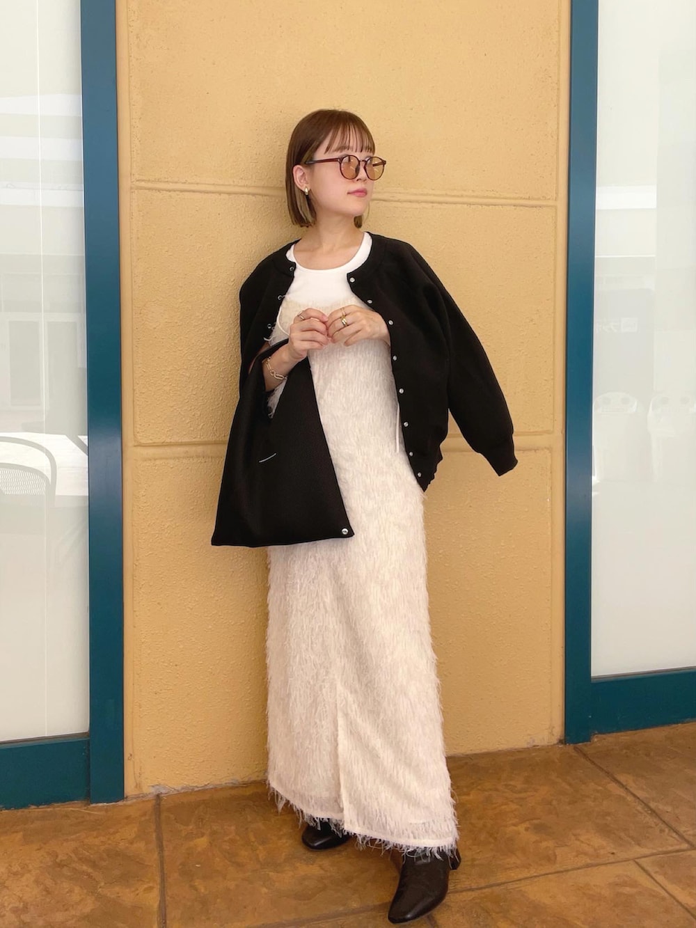 ブラック系のカーディガン/ボレロ、ホワイト系のワンピース、ブラック系のトートバッグを着用したレディースの秋コーディネートの2枚目の写真