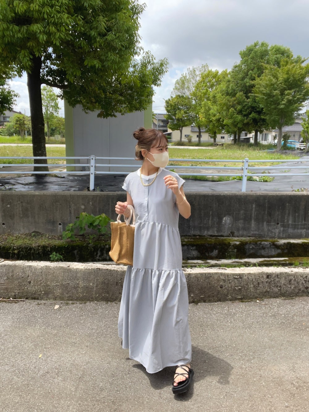 ブラック系のワンピース、ベージュ系のショルダーバッグ、ブラック系のサンダルを着用したレディースの夏コーディネートの3枚目の写真