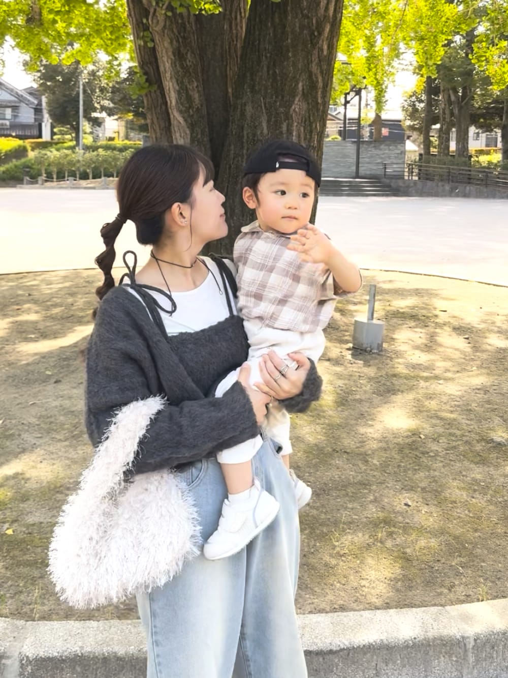 グレー系のカーディガン/ボレロ、ブルー系のデニムパンツ、ホワイト系のバッグを着用したレディースの秋コーディネートの5枚目の写真