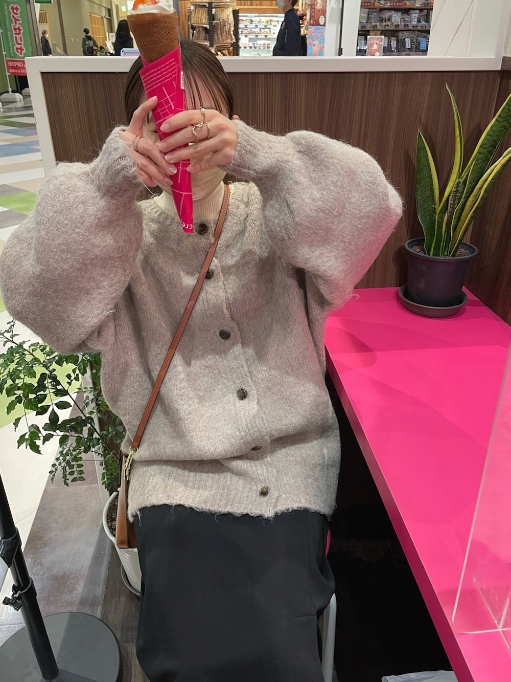 ホワイト系のニット/セーター、ブラック系のスカート、ブラウン系のショルダーバッグを着用したレディースの冬コーディネートの5枚目の写真