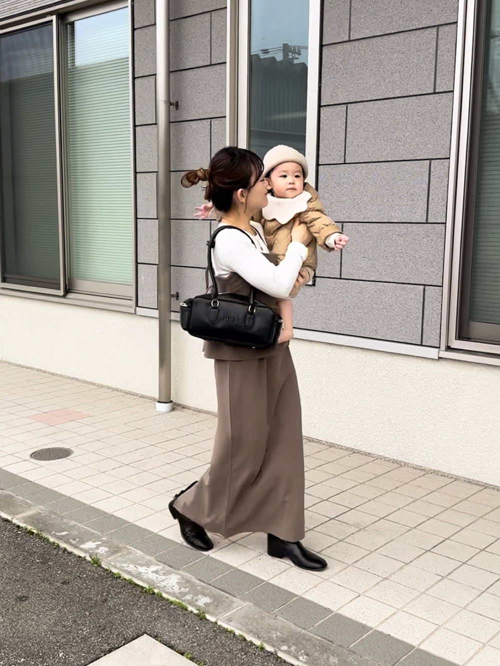 ブラウン系のワンピース、ブラック系のボストンバッグ、ブラック系のその他シューズを着用したレディースの春コーディネートの2枚目の写真