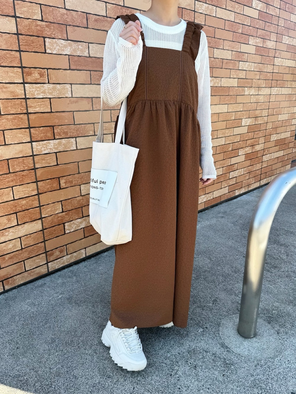 ブラウン系のワンピース、ホワイト系のトップス、ホワイト系のトートバッグを着用したレディースの春コーディネートの3枚目の写真