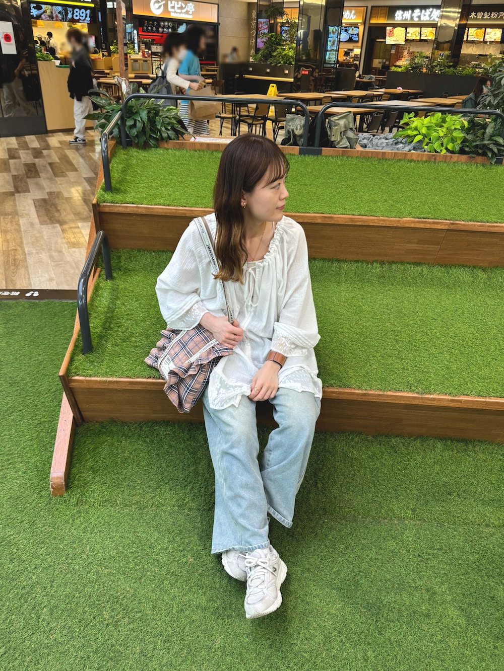 ホワイト系のトップス、ブルー系のデニムパンツ、ピンク系のトートバッグを着用したレディースの春コーディネートの5枚目の写真