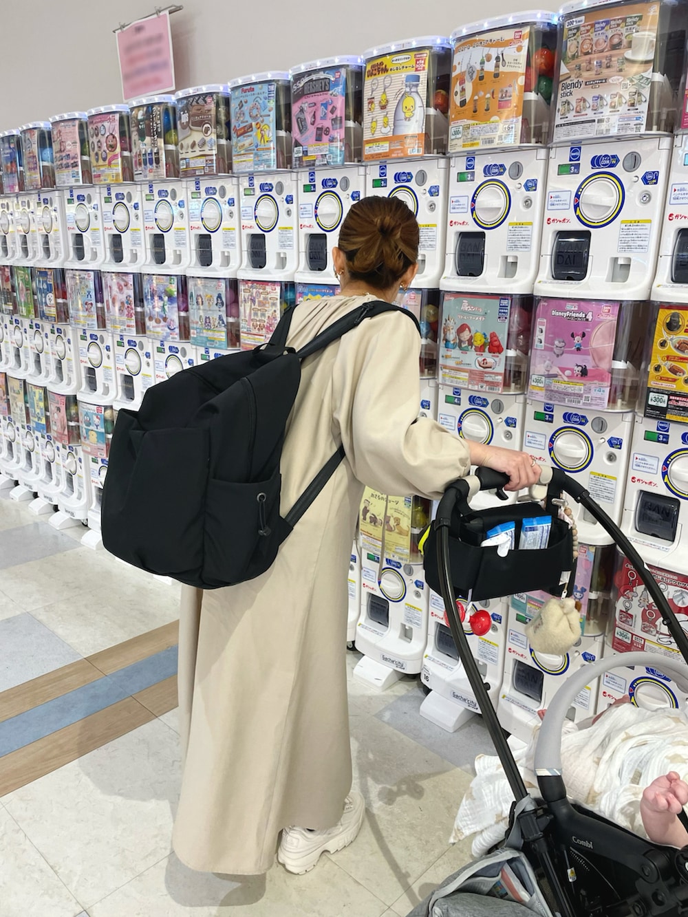 ベージュ系のワンピース、ブラック系のバックパック/リュック、ホワイト系のシューズを着用したレディースの春コーディネートの3枚目の写真