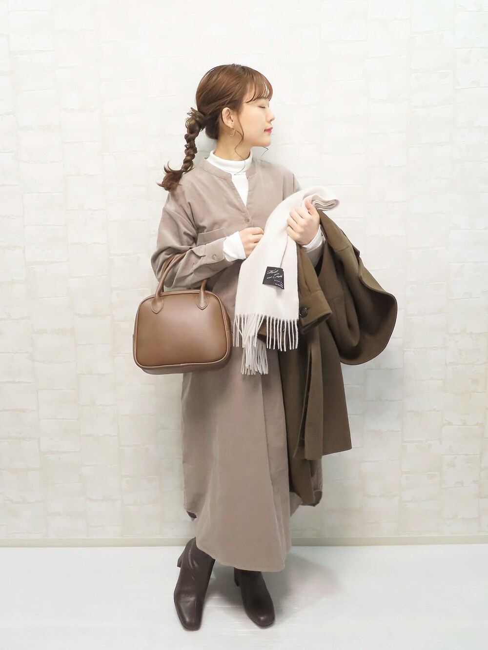 ベージュ系のワンピース、ホワイト系のTシャツ/カットソー、ブラウン系のジャケット/アウターを着用したレディースの冬コーディネートの2枚目の写真