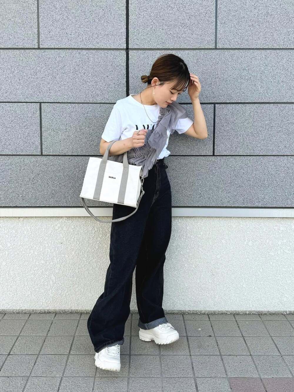 ホワイト系のトートバッグ、グレー系のその他トップス、ブラック系のデニムパンツを着用したレディースの春コーディネートの2枚目の写真