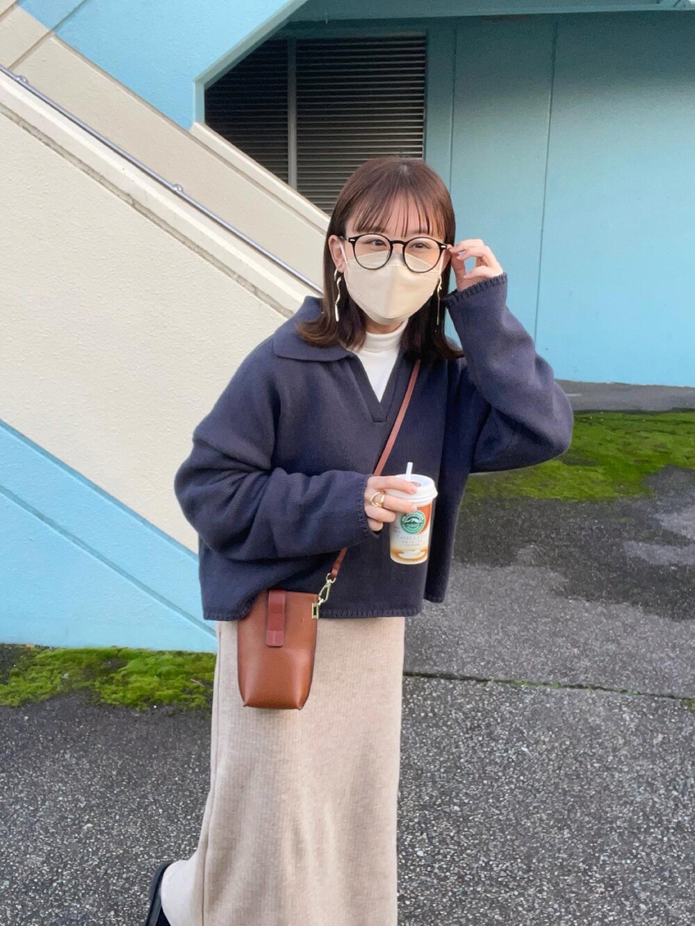 グレー系のニット/セーター、ホワイト系のTシャツ/カットソー、ベージュ系のスカートを着用したレディースの秋コーディネートの3枚目の写真