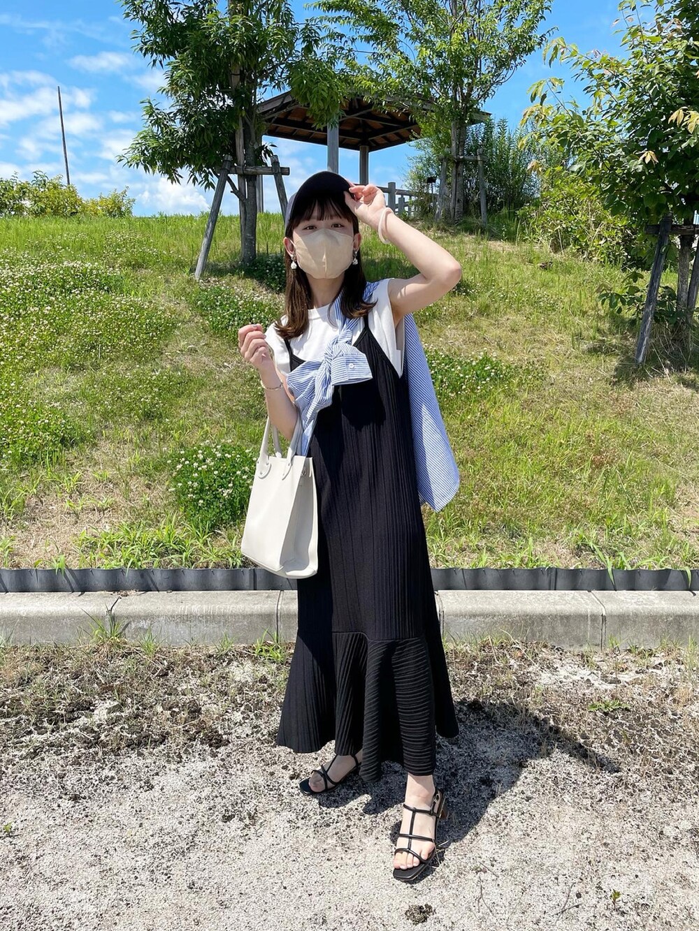 ホワイト系のトートバッグ、ブラック系のワンピース、ホワイト系のニット/セーターを着用したレディースの夏コーディネートの5枚目の写真