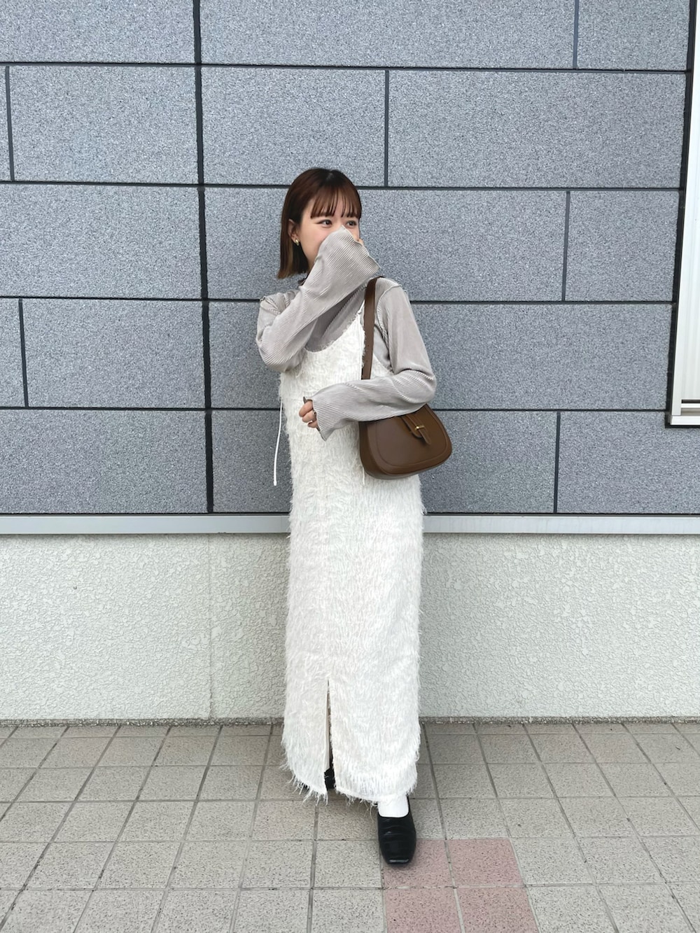 ホワイト系のワンピース、ベージュ系のTシャツ/カットソー、ブラウン系のバッグを着用したレディースの秋コーディネートの3枚目の写真
