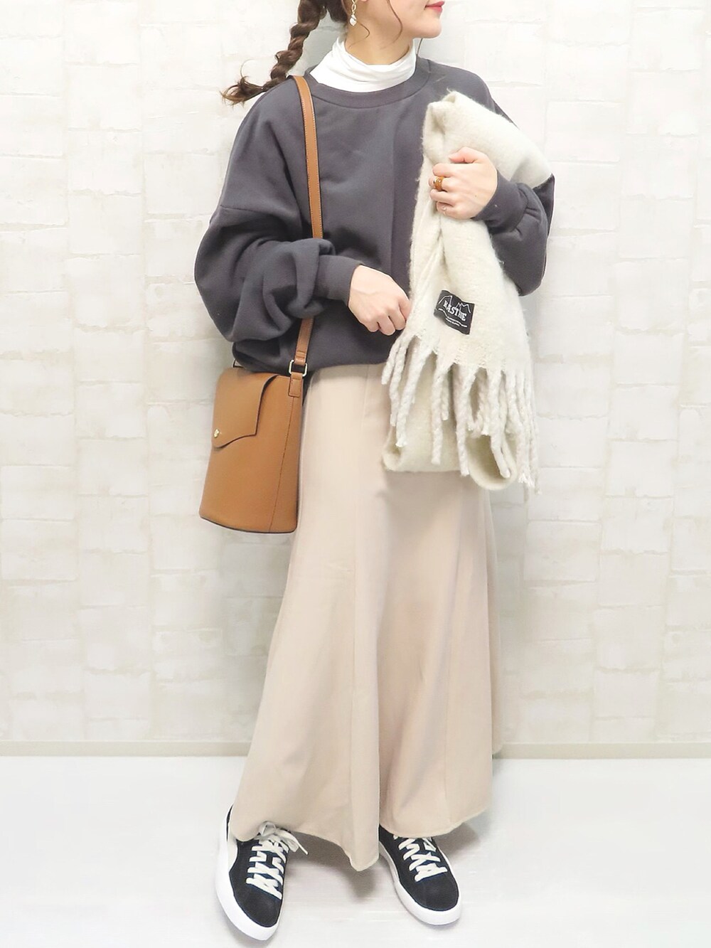 ホワイト系のトップス、ベージュ系のスカート、イエロー系のショルダーバッグを着用したレディースの冬コーディネートの2枚目の写真