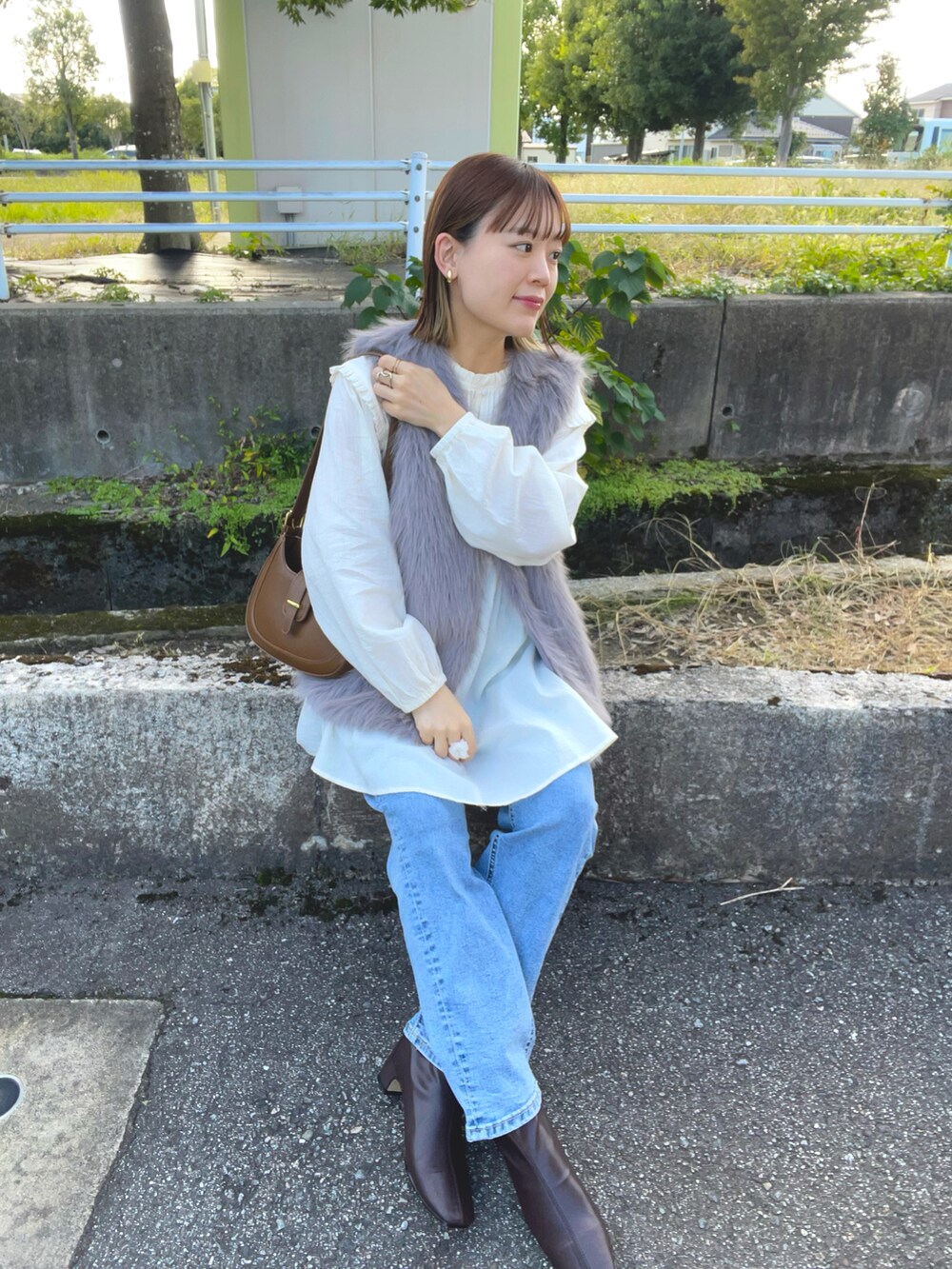 ベージュ系のシャツ/ブラウス、グレー系のベスト、ブラウン系のバッグを着用したレディースの秋コーディネートの3枚目の写真