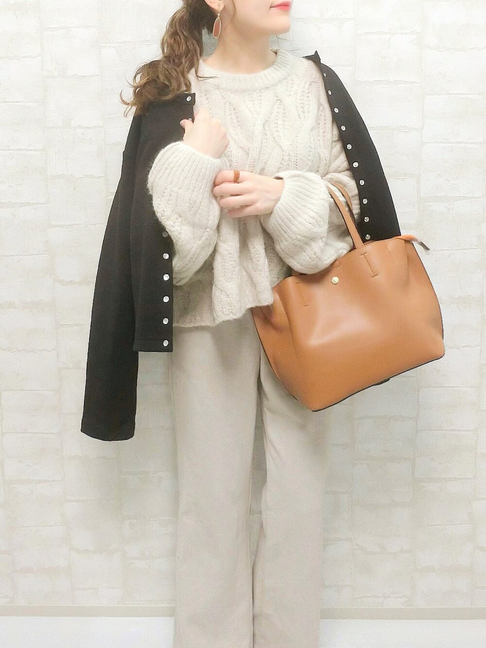 ブラック系のカーディガン/ボレロ、ホワイト系のニット/セーター、ホワイト系のスラックスを着用したレディースの秋コーディネートの2枚目の写真