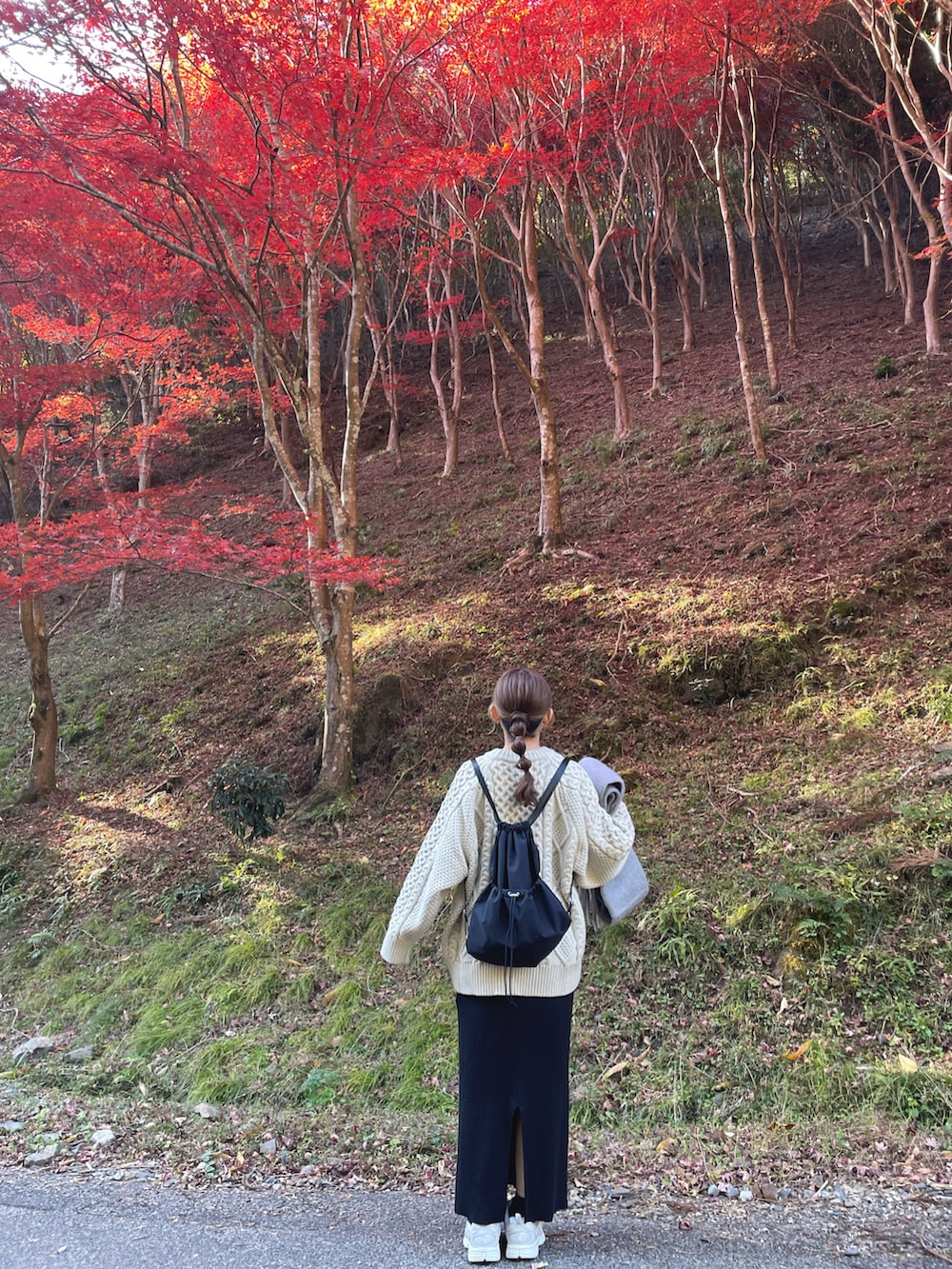 ホワイト系のニット/セーター、ブラック系のバックパック/リュック、グレー系のマフラーを着用したレディースの冬コーディネートの4枚目の写真