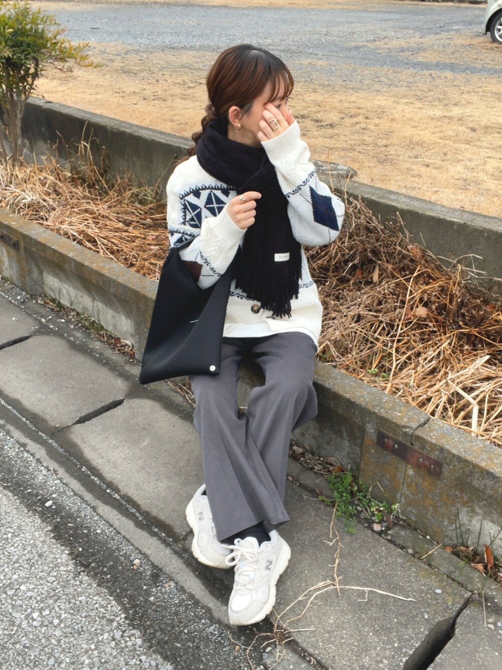 ベージュ系のニット/セーター、グレー系のその他パンツ、ブラック系のマフラーを着用したレディースの冬コーディネートの4枚目の写真