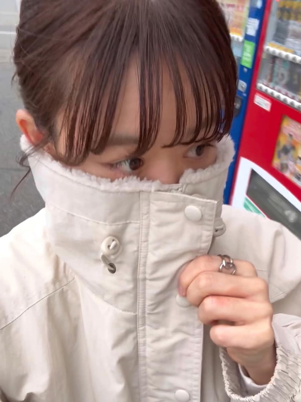 ホワイト系のブルゾン、グレー系のスカート、ブラック系のトートバッグを着用したレディースの冬コーディネートの4枚目の写真