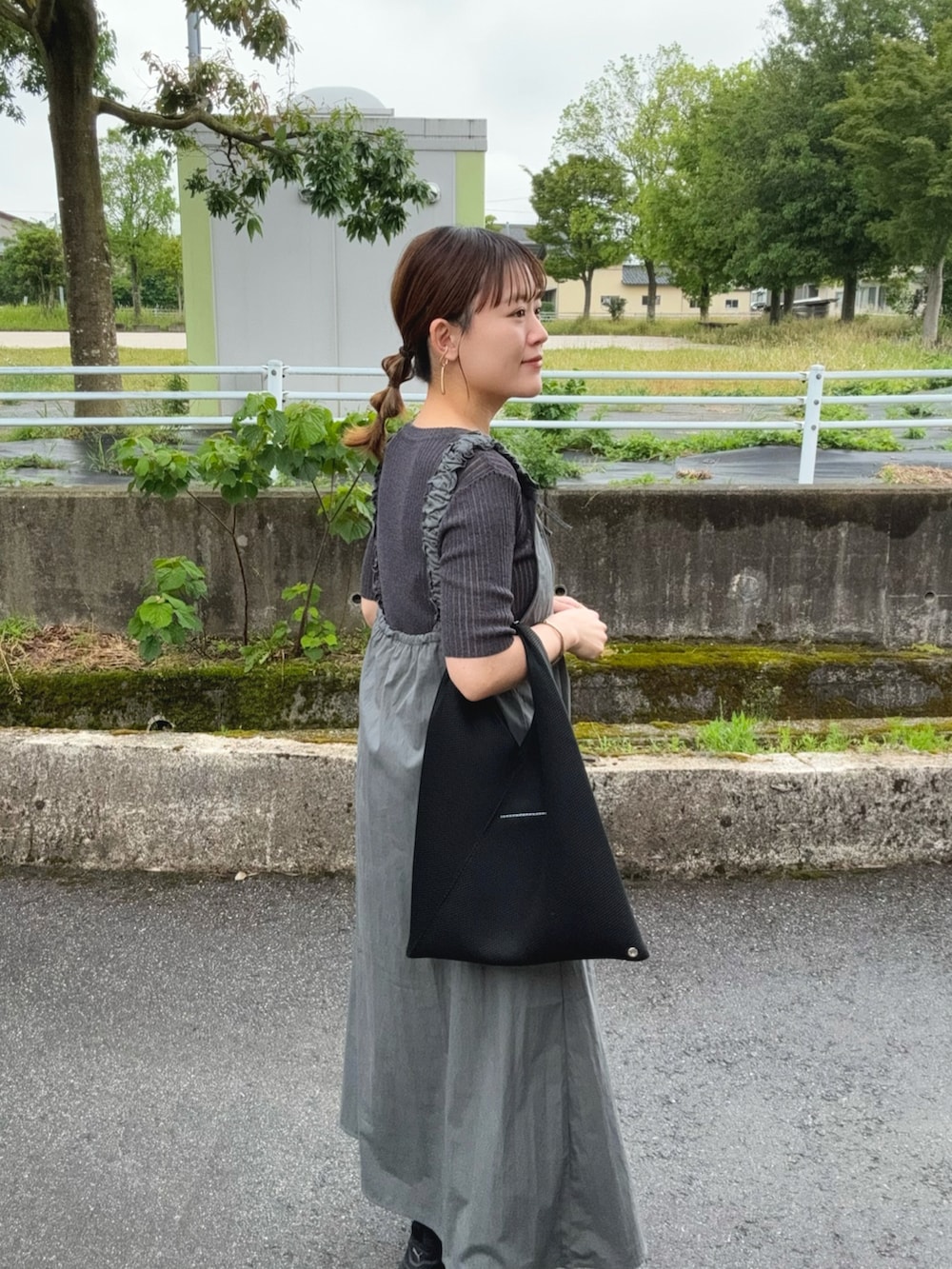 グレー系のワンピース、グレー系のトップス、ブラック系のトートバッグを着用したレディースの夏コーディネートの2枚目の写真