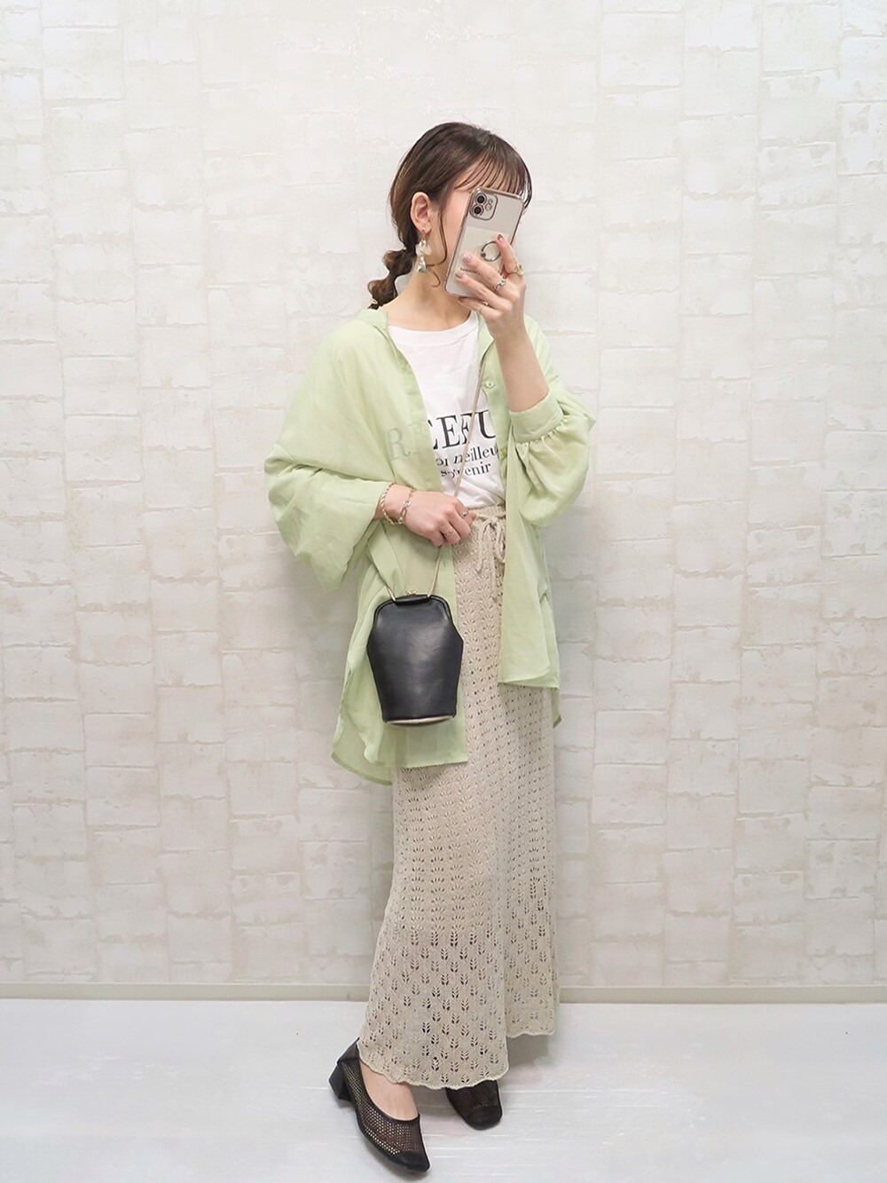 ベージュ系のスカート、ホワイト系のTシャツ/カットソー、ブラック系のパンプスを着用したレディースの春コーディネートの2枚目の写真