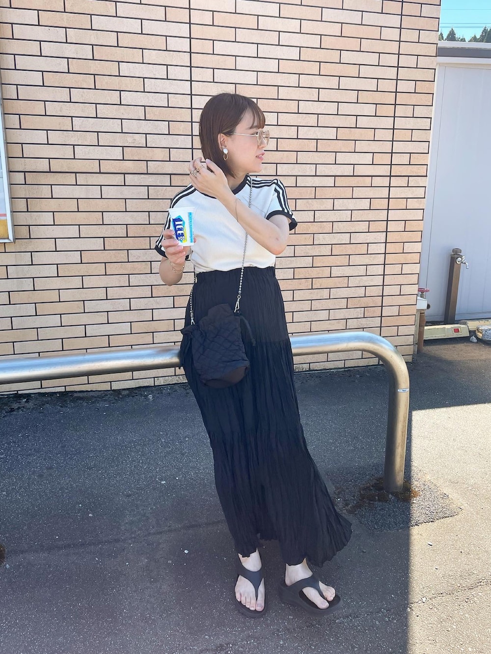 ホワイト系のTシャツ/カットソー、ブラック系のスカート、ブラック系のショルダーバッグを着用したレディースの夏コーディネートの4枚目の写真