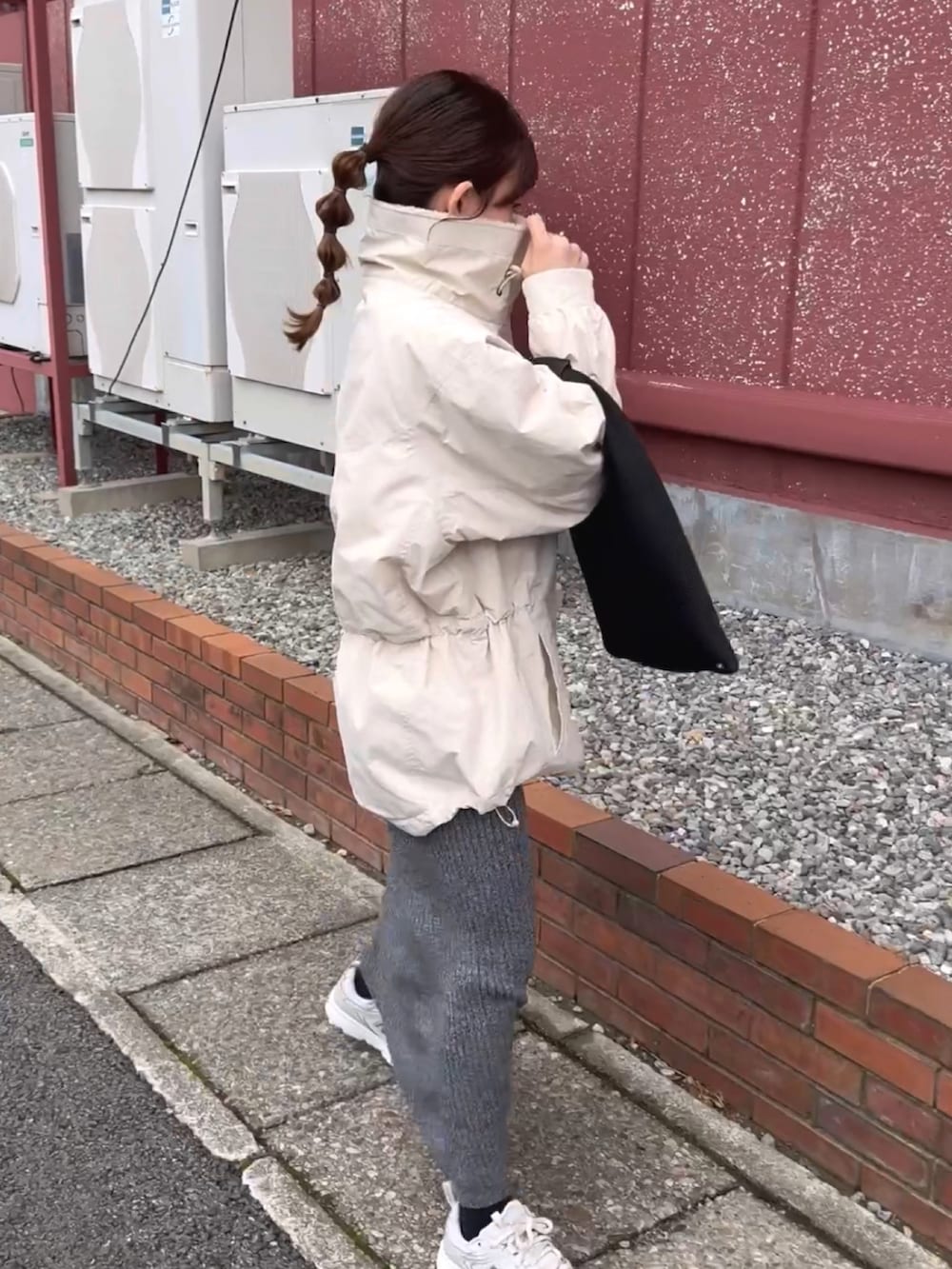 ホワイト系のブルゾン、グレー系のスカート、ブラック系のトートバッグを着用したレディースの冬コーディネートの3枚目の写真