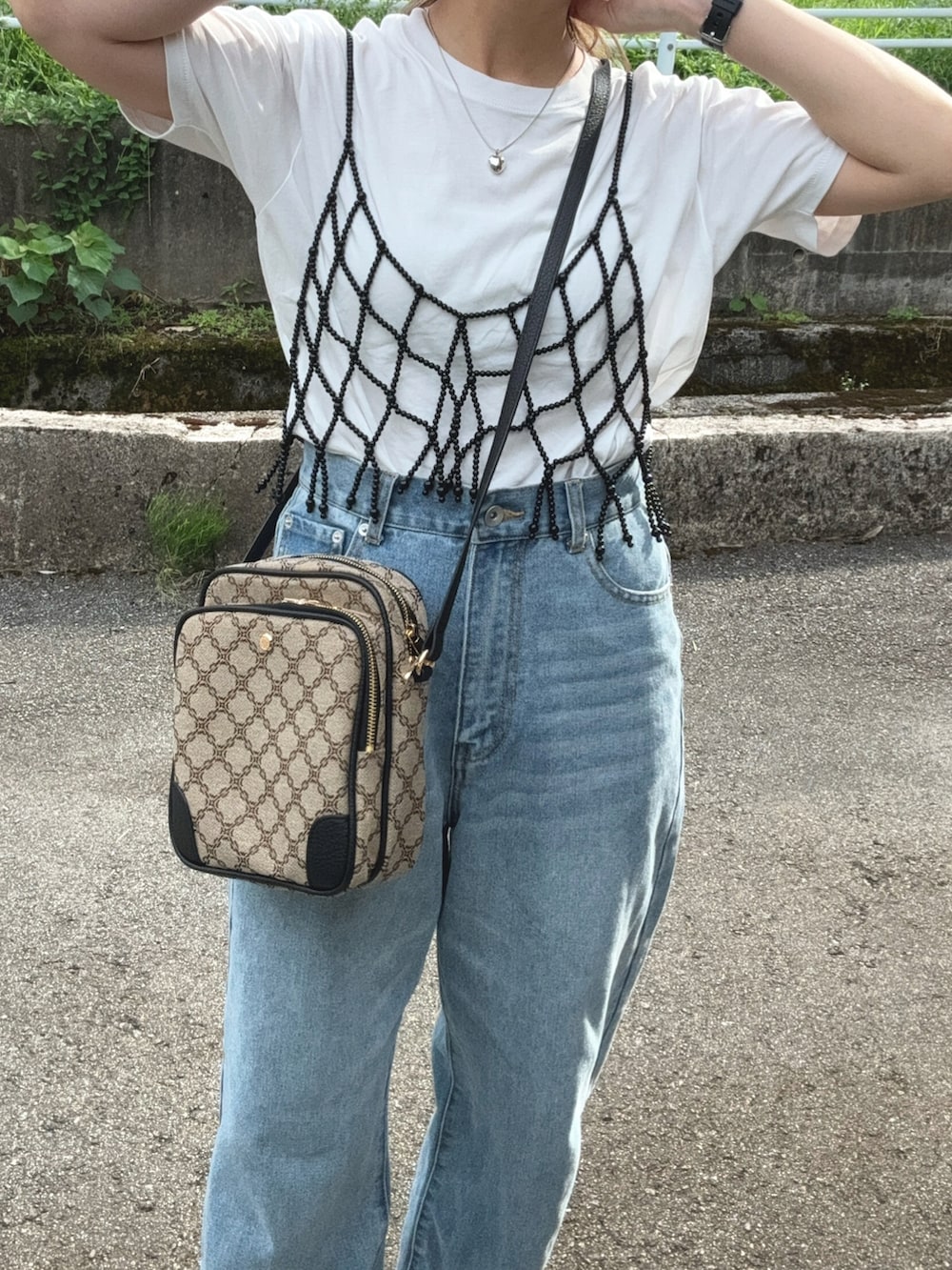 ブラック系のキャミソール、ブルー系のデニムパンツ、ブラック系のサンダルを着用したレディースの夏コーディネートの3枚目の写真