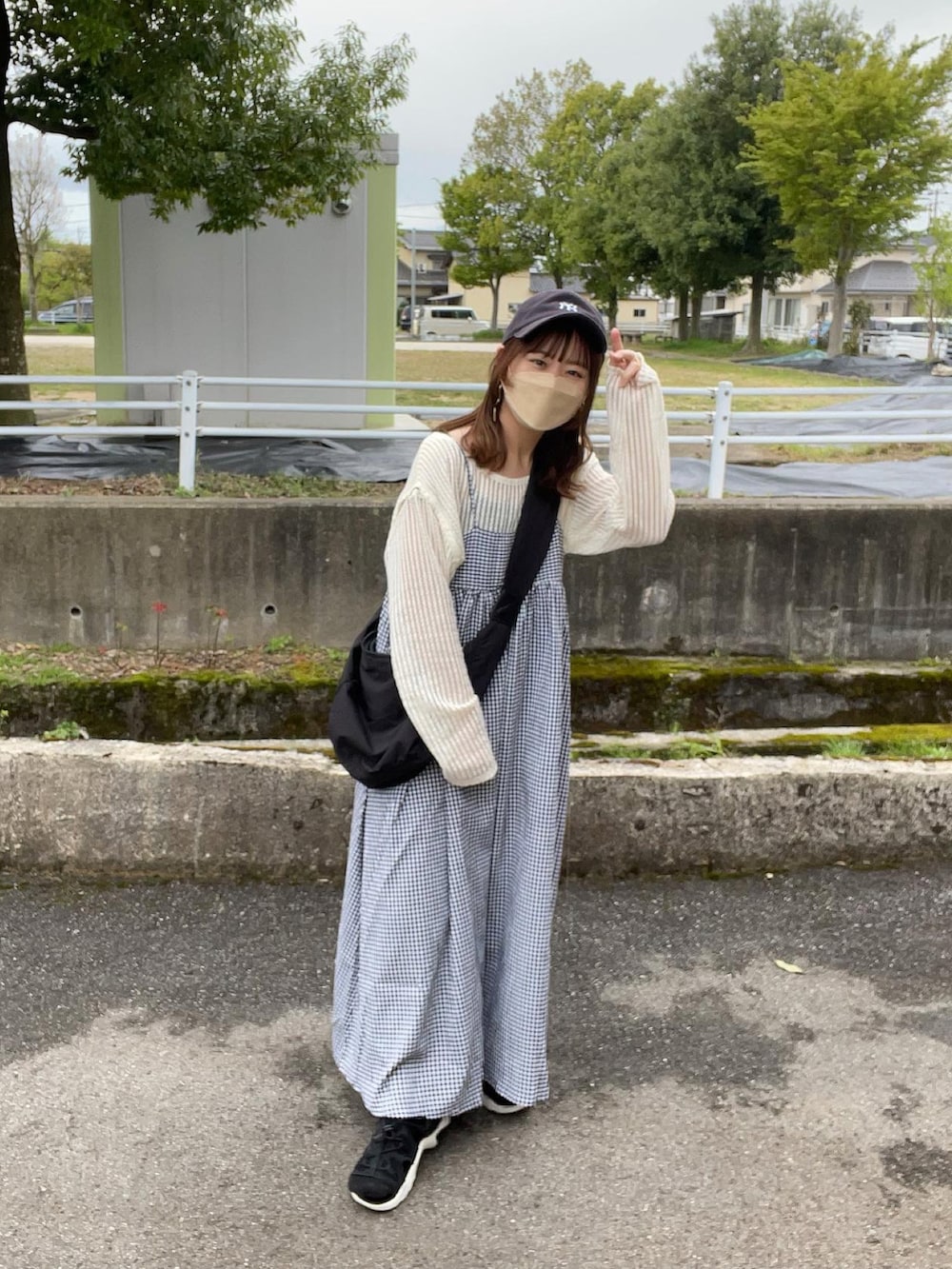 ホワイト系のワンピース、ベージュ系のTシャツ/カットソー、ブラック系のキャミソールを着用したレディースの春コーディネートの2枚目の写真