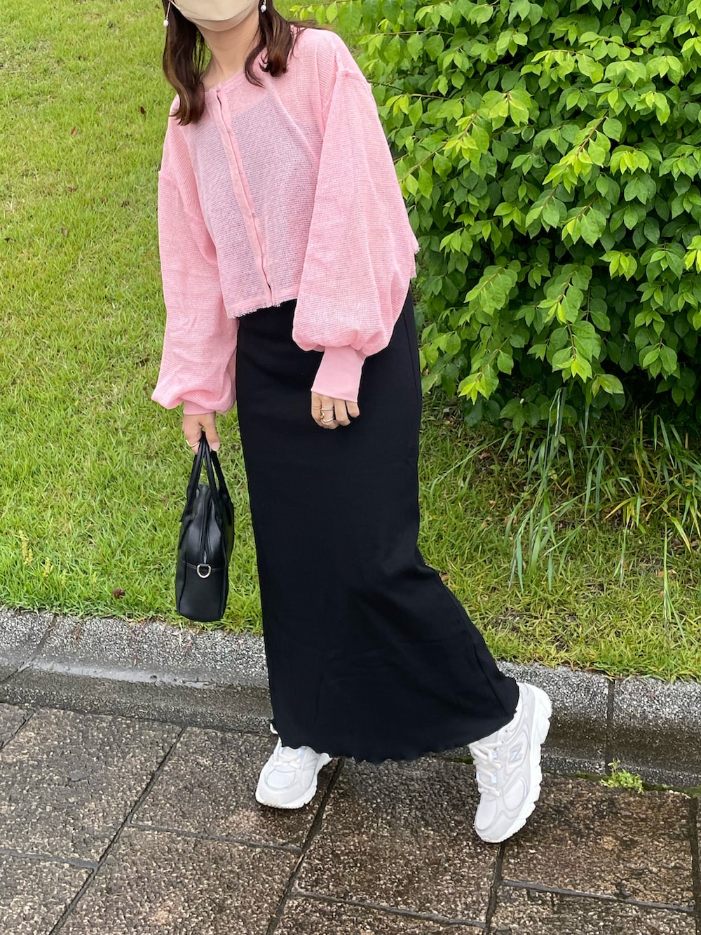 ピンク系のカーディガン/ボレロ、ブラック系のワンピース、ホワイト系のスニーカーを着用したレディースの春コーディネートの5枚目の写真