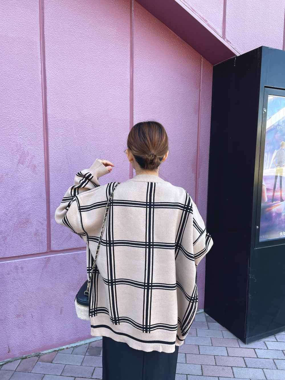 ベージュ系のカーディガン/ボレロ、ブラック系のワンピース、ホワイト系のスニーカーを着用したレディースの冬コーディネートの4枚目の写真