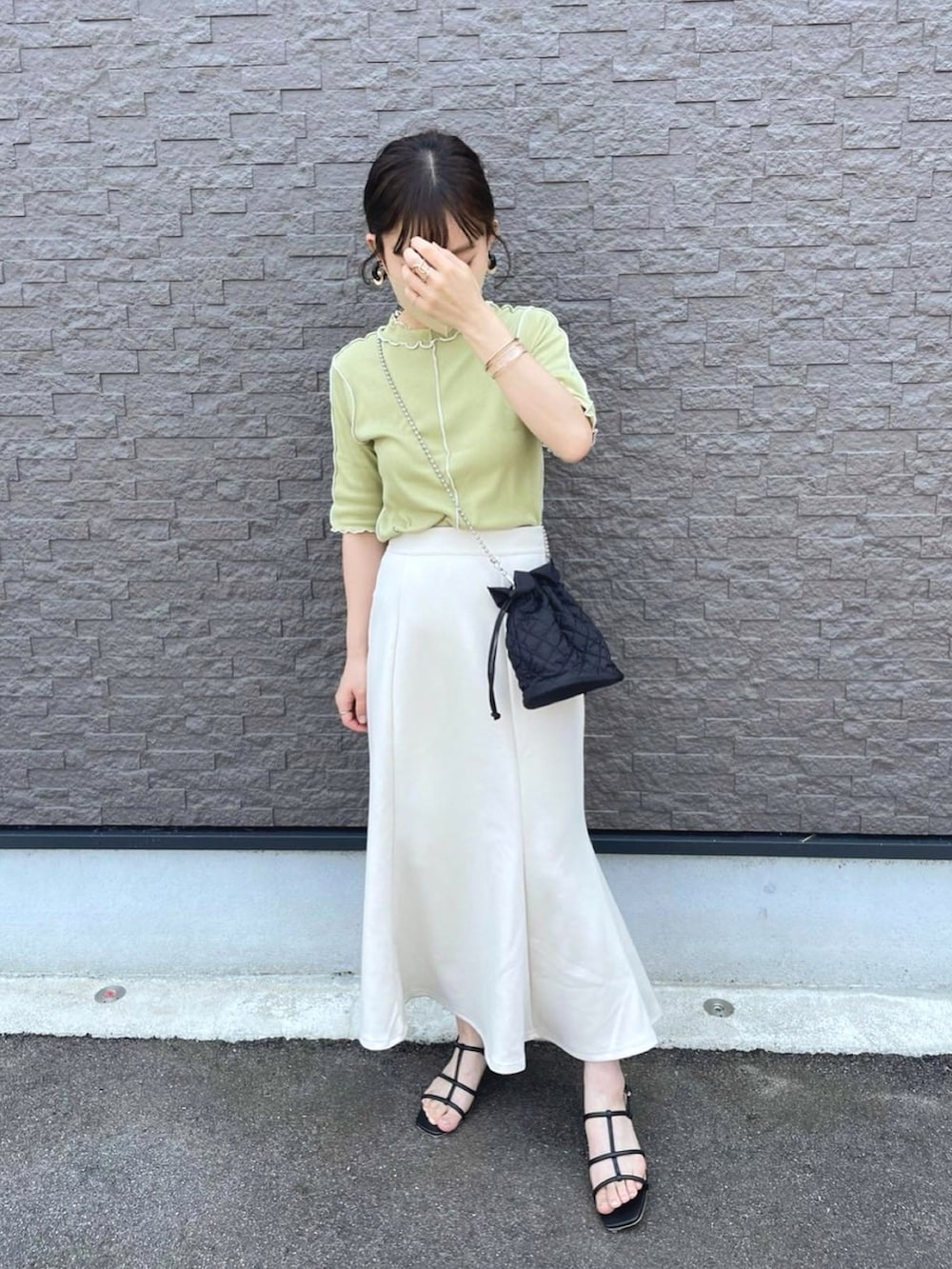 グリーン系のTシャツ/カットソー、ホワイト系のスカート、ブラック系のショルダーバッグを着用したレディースの夏コーディネートの2枚目の写真