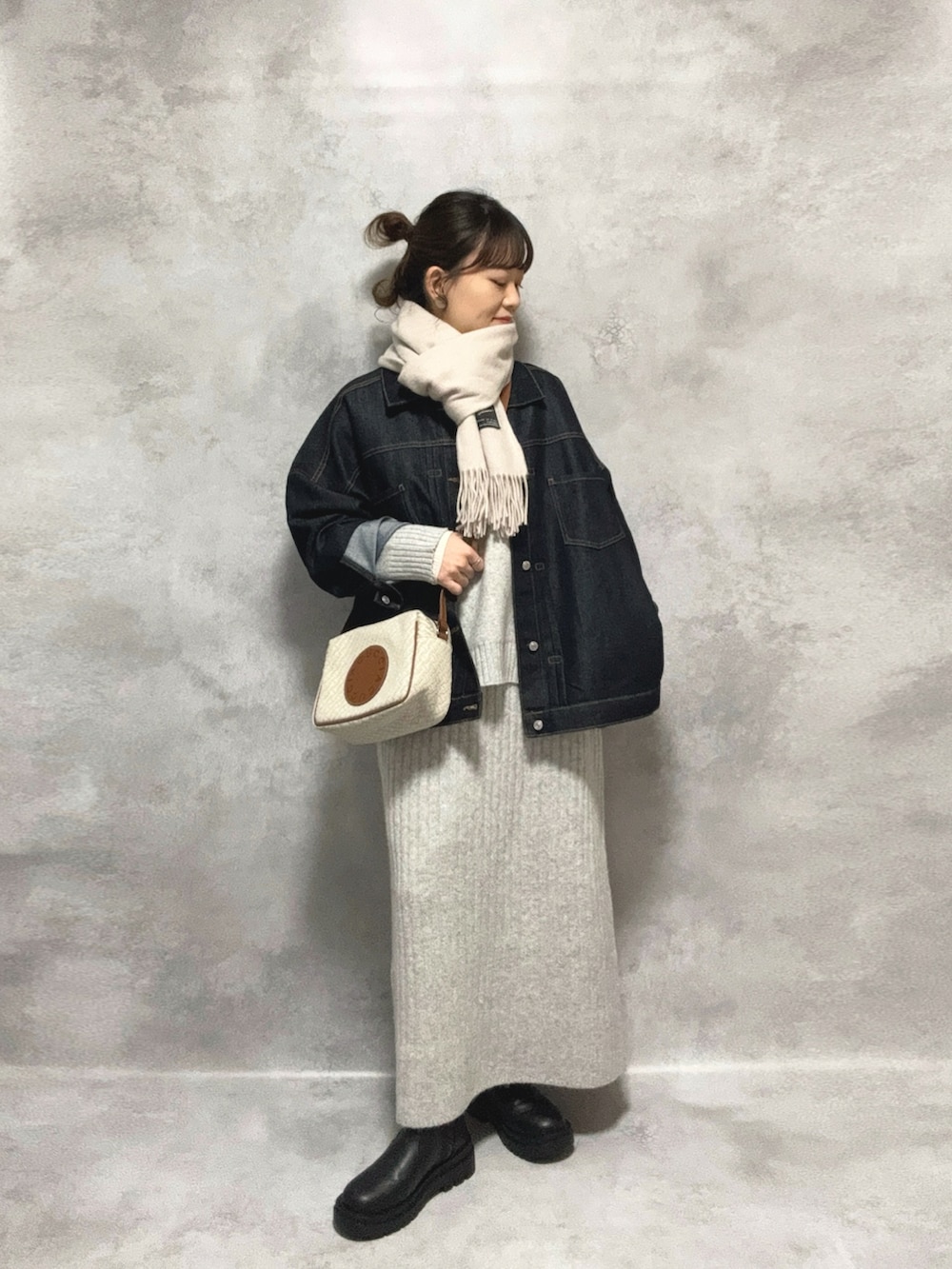 グレー系のワンピース、ブルー系のデニムジャケット、ホワイト系のショルダーバッグを着用したレディースの秋コーディネートの3枚目の写真