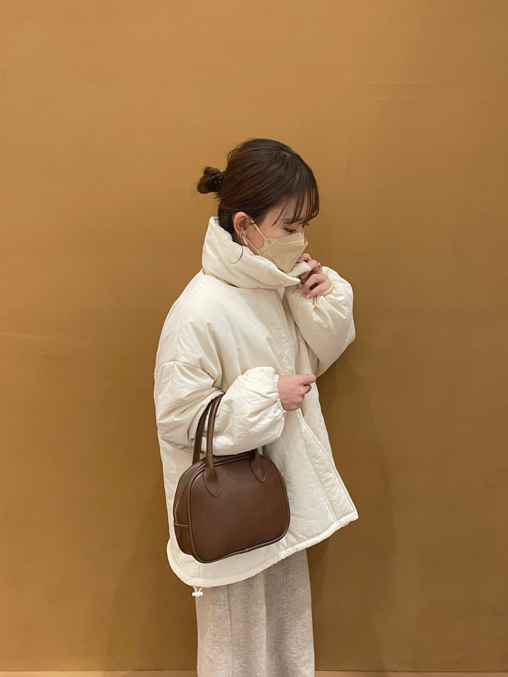 ホワイト系のブルゾン、ホワイト系のニット/セーター、ベージュ系のスカートを着用したレディースの冬コーディネートの2枚目の写真