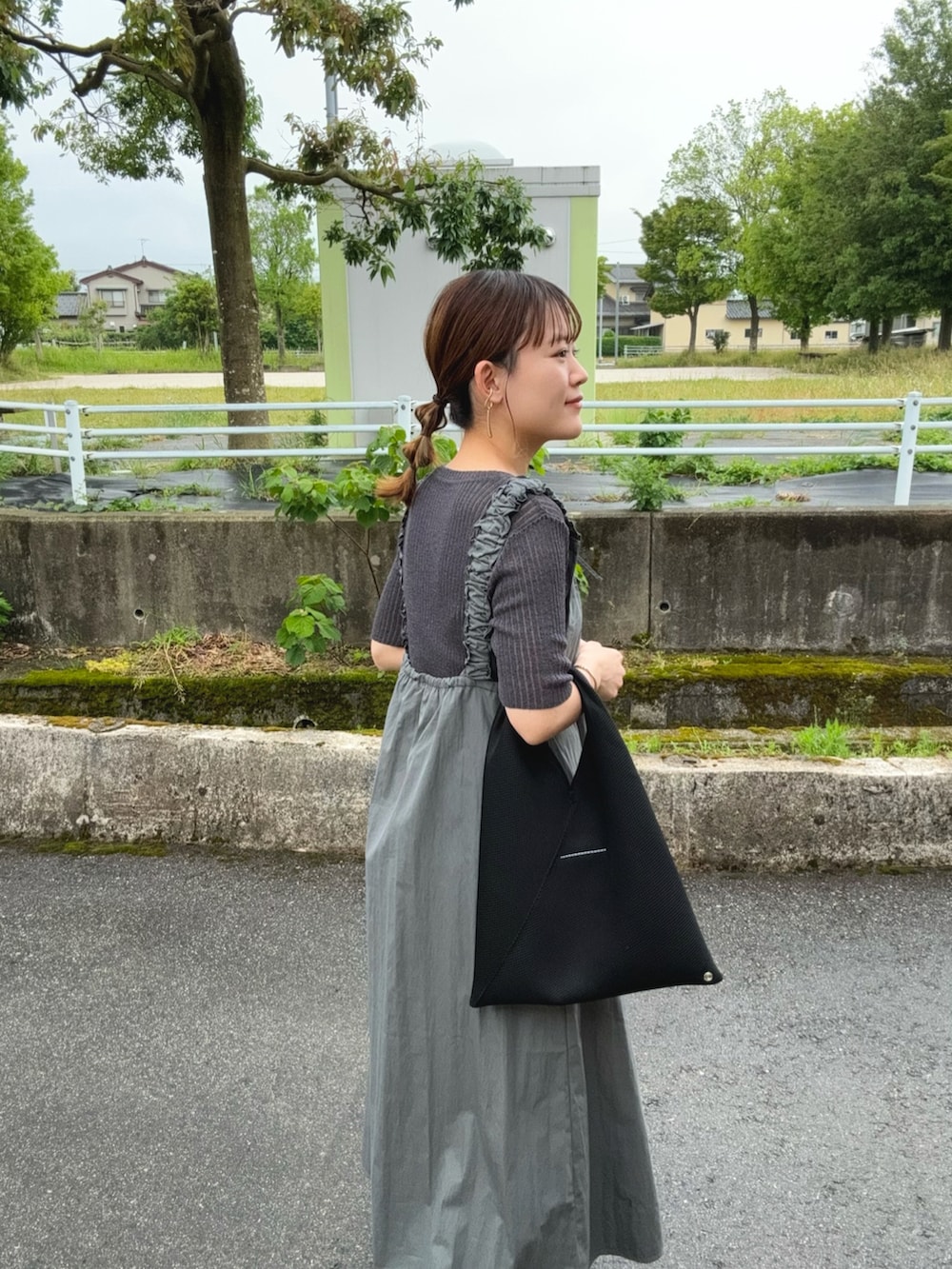グレー系のワンピース、グレー系のトップス、ブラック系のトートバッグを着用したレディースの夏コーディネートの5枚目の写真