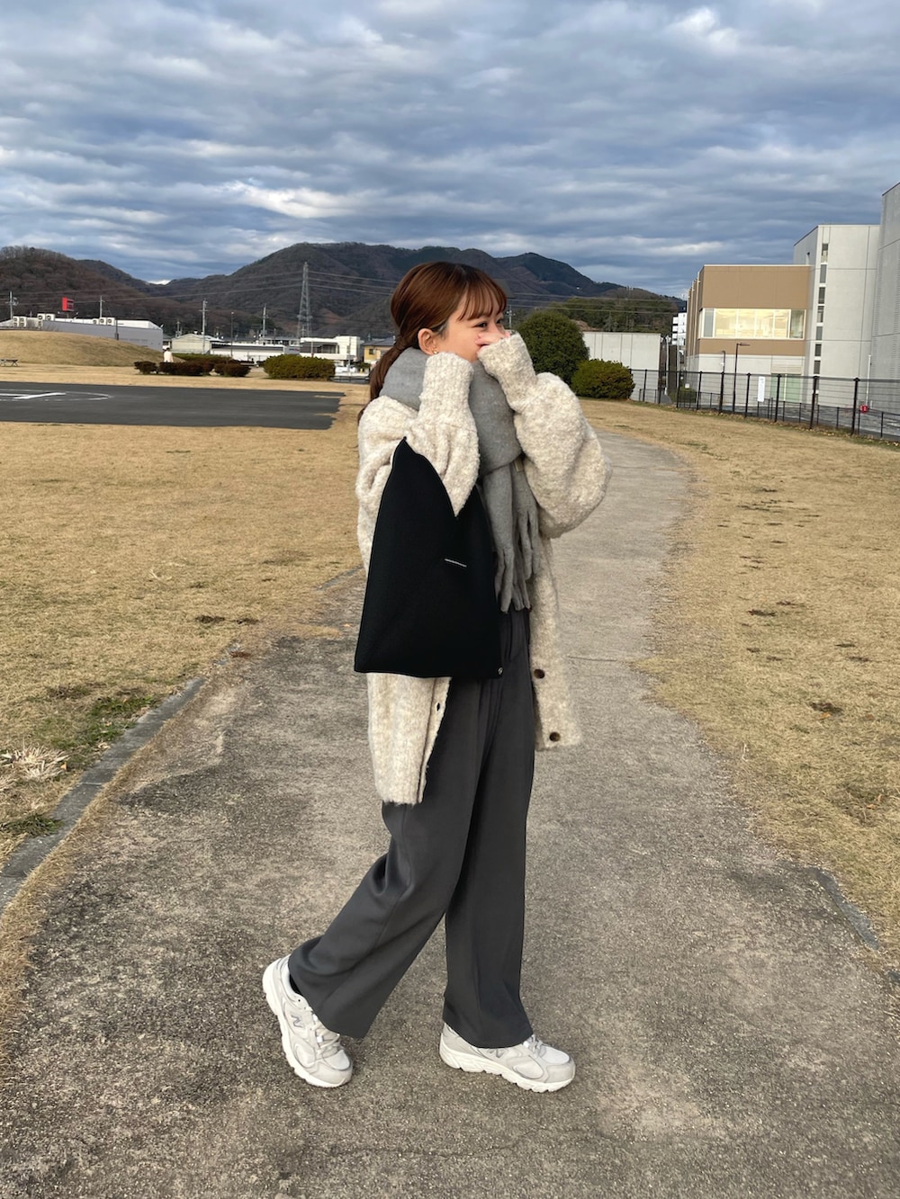 ベージュ系のカーディガン/ボレロ、グレー系のその他パンツ、ブラック系のトートバッグを着用したレディースの冬コーディネートの4枚目の写真