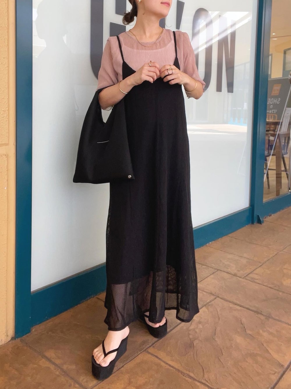 ピンク系のシャツ/ブラウス、ブラック系のワンピース、ブラック系のトートバッグを着用したレディースの夏コーディネートの3枚目の写真