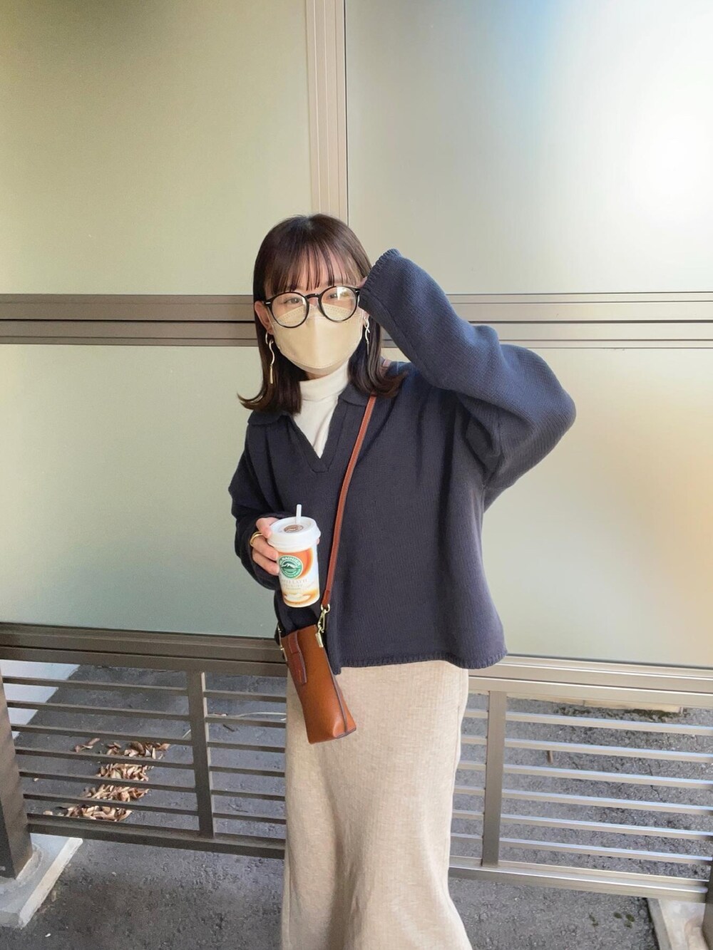 グレー系のニット/セーター、ホワイト系のTシャツ/カットソー、ベージュ系のスカートを着用したレディースの秋コーディネートの5枚目の写真