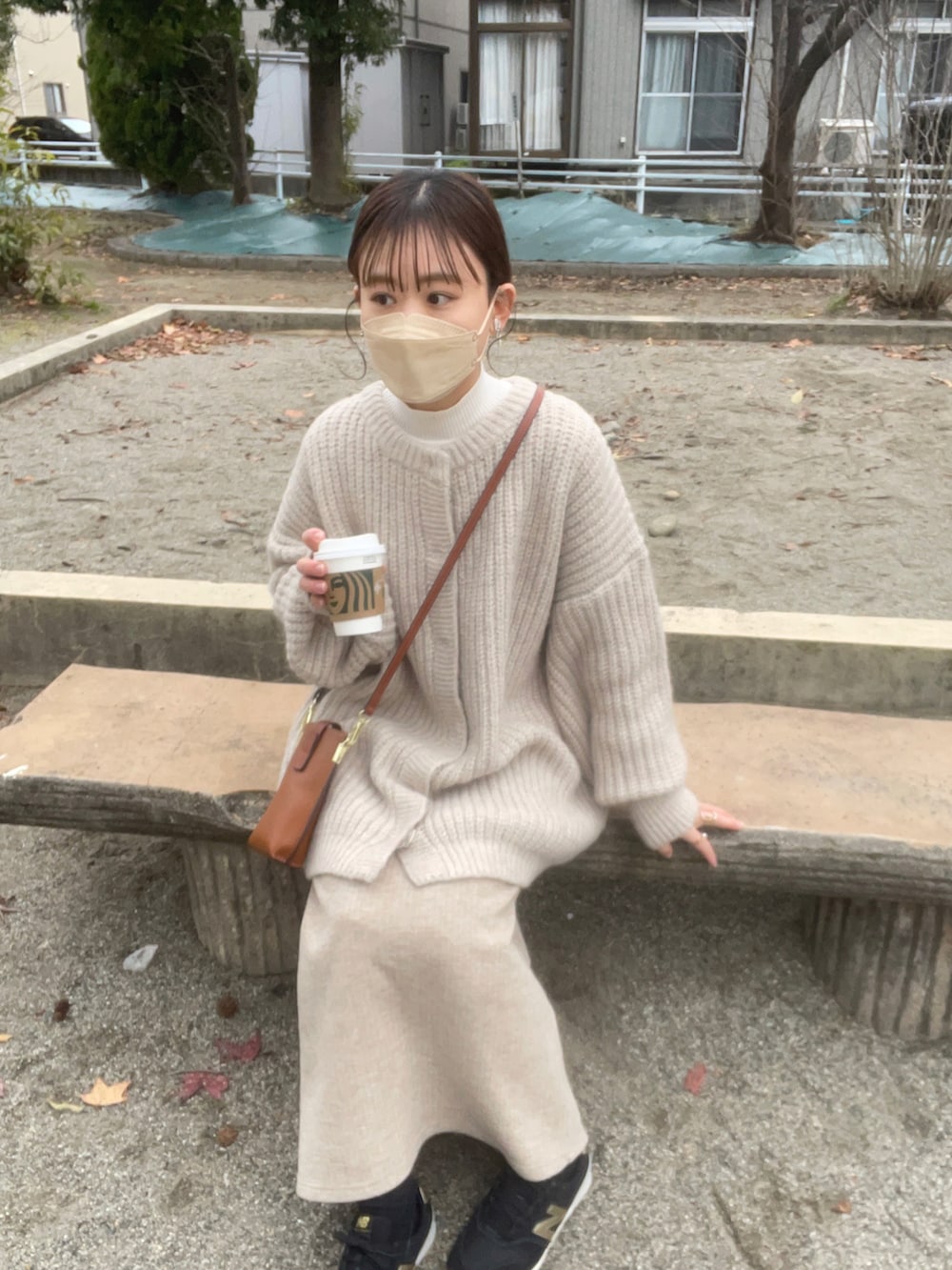 ホワイト系のカーディガン/ボレロ、ホワイト系のニット/セーター、ベージュ系のスカートを着用したレディースの冬コーディネートの4枚目の写真