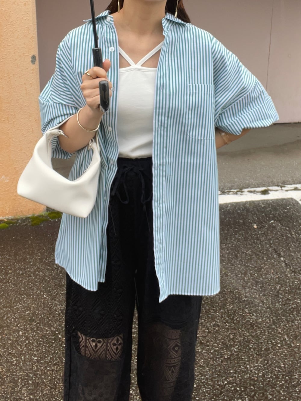 グリーン系のシャツ/ブラウス、ブラック系のその他パンツ、ホワイト系のキャミソールを着用したレディースの春コーディネートの3枚目の写真